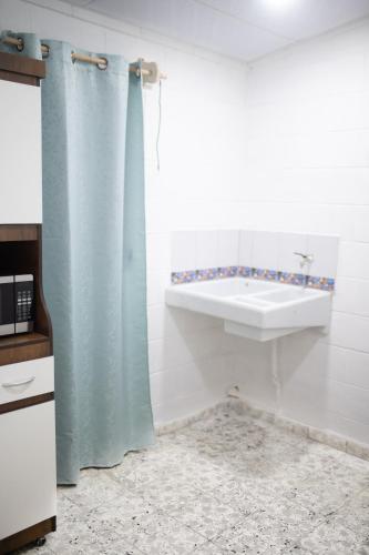 a bathroom with a shower curtain and a sink at Cowboys Home in Juayúa