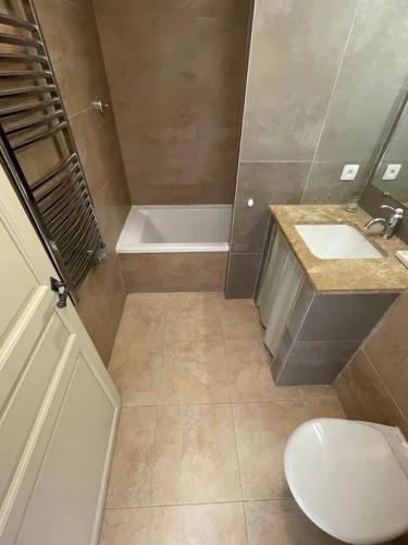 a bathroom with a toilet and a sink and a tub at Maison Un Deux Trois in Saint-Laurent-de-la-Cabrerisse