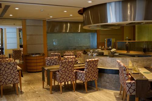 a restaurant with tables and chairs and a kitchen at Taj Chandigarh in Chandīgarh