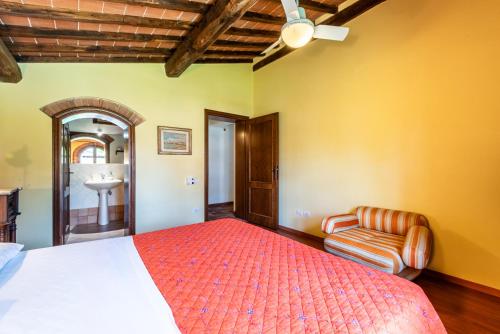 a bedroom with a bed and a chair and a sink at Appartamento Maria in San Gimignano