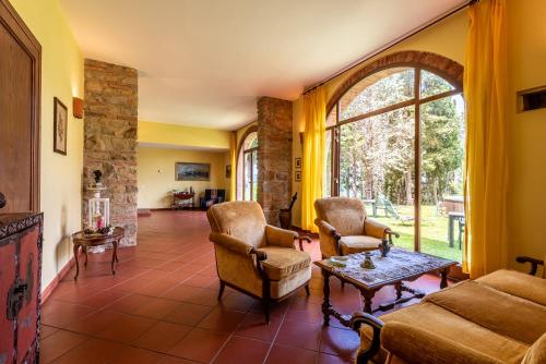 a living room with a couch and chairs and a table at Appartamento Maria in San Gimignano