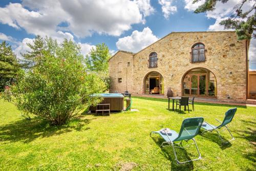 a yard with two chairs and a building at Appartamento Maria in San Gimignano