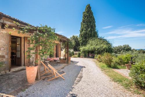 a gravel path next to a building with a bench at Melograno Apartment Podere Giardino in Montalcino
