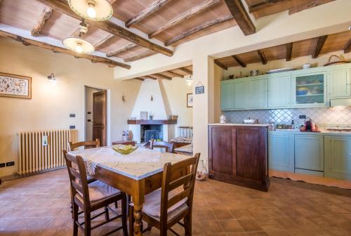 a kitchen with a table and chairs in a room at Melograno Apartment Podere Giardino in Montalcino