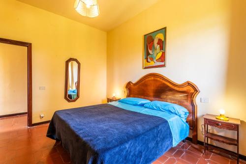 a bedroom with a large bed with a blue blanket at Appartamento San Benedetto in San Gimignano