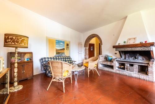 a living room with a table and chairs and a fireplace at Appartamento San Benedetto in San Gimignano