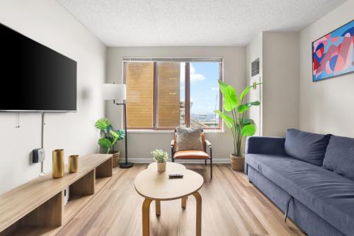 a living room with a blue couch and a table at The Perfect Stay Awaits For You in Our Apt! in Arlington