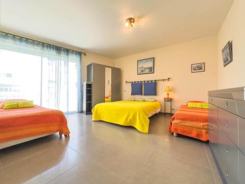 - une chambre avec 2 lits dotés de draps jaunes et oranges dans l'établissement Le Rooftop by Winsome Destination, à Cannes