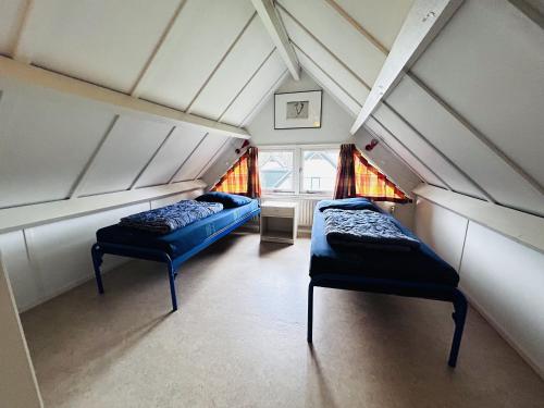 Zimmer im Dachgeschoss mit 2 Betten und einem Fenster in der Unterkunft Bungalowpark Simpelveld - Delta 154 in Simpelveld