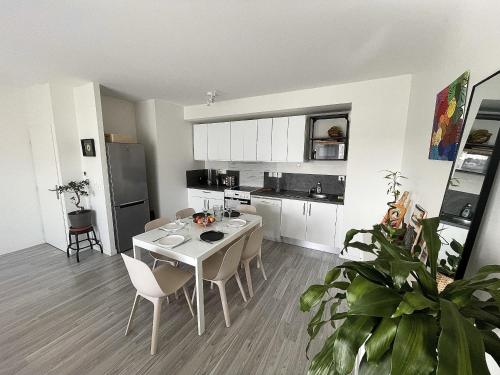 une cuisine et une salle à manger avec une table et des chaises dans l'établissement Le peupliers, avec parking pour 6 personnes, à La Rochelle