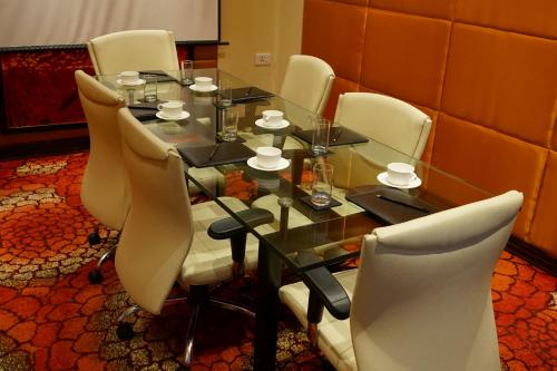 a dining room table with white chairs around it at Taj Chandigarh in Chandīgarh