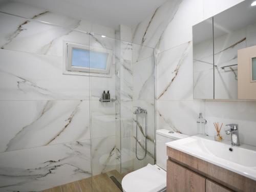 a bathroom with a shower and a toilet and a sink at Dolce Vista VN Luxury Apartments in Kardamaina