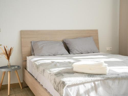 a bed with a wooden headboard with a white towel on it at Dolce Vista VN Luxury Apartments in Kardamaina