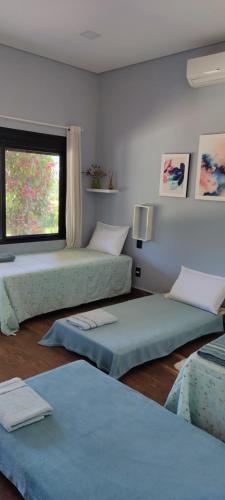 a room with three beds and a window at Chalé de alto padrão em condomínio in Santa Rita do Sapucaí