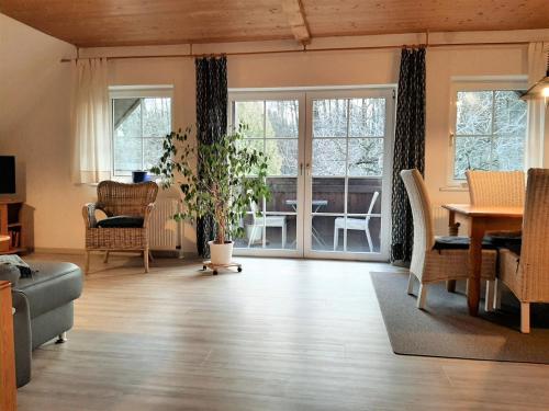 a living room with a table and chairs and windows at Fewo Stricker 32 in Walkenried
