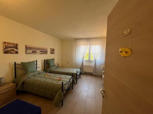 a bedroom with two beds and a window at Ca' Nadia in Campalto