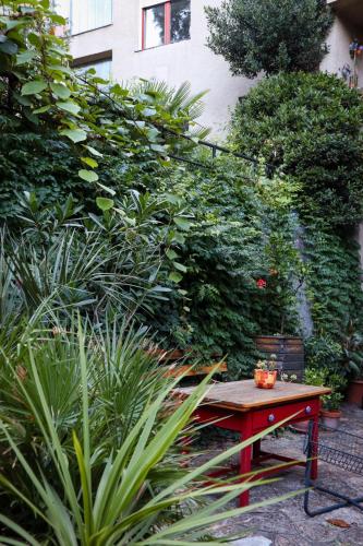 a red bench in a garden with plants at Cozy studio at the Castle in Budapest
