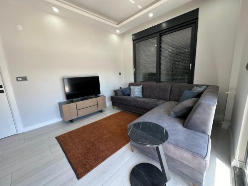 a living room with a couch and a flat screen tv at Tunc Suites in Antalya