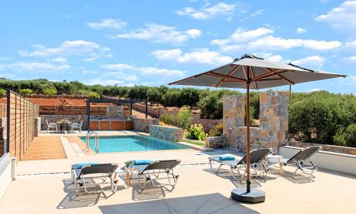 a patio with an umbrella and chairs and a pool at Ferienhaus Für 10 Personen In Kalo Chorio, Kreta Ost Kreta in Pírgos