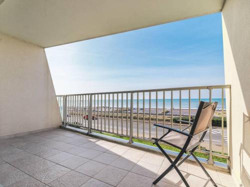 une chaise sur un balcon avec vue sur la plage dans l'établissement Studio cabine au bord de mer sans Wi-Fi - FR-1-821-27, à Le Touquet-Paris-Plage