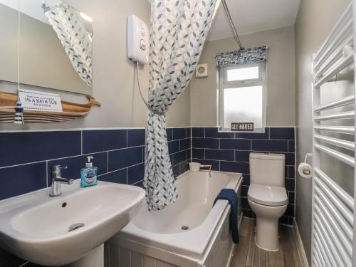 a bathroom with a sink and a tub and a toilet at Lychgate View Cottage in Hull