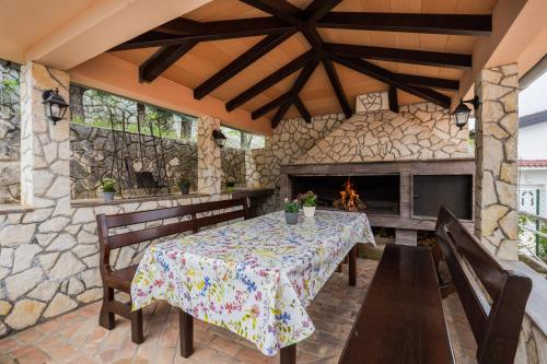 a patio with a table and chairs and a fireplace at Panoramare in Zagorje