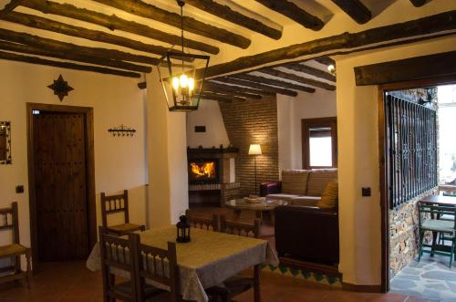 a living room with a table and a fireplace at Casa Número 7 in Válor