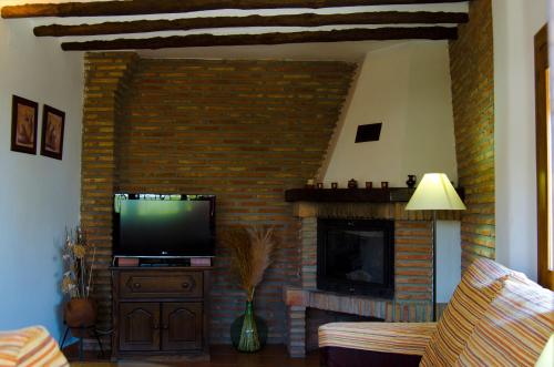 a living room with a tv and a fireplace at Casa Número 7 in Válor