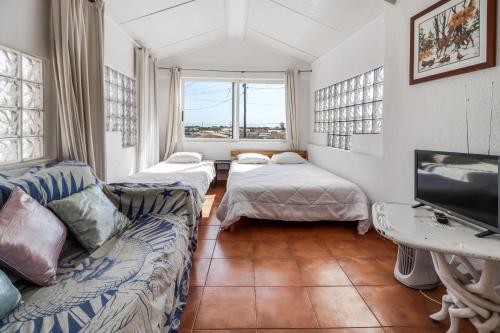 a living room with a couch and a tv at Saude Beach House in Costa da Caparica