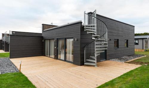 a black house with a spiral staircase on a deck at Cropton Lodge at Galtres Retreat in Pickering