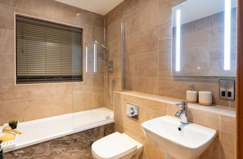une salle de bain avec un lavabo, des toilettes et une baignoire dans l'établissement Cropton Lodge at Galtres Retreat, à Pickering