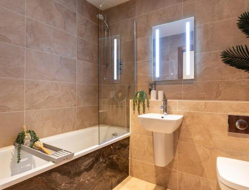 une salle de bain avec un lavabo, des toilettes et une baignoire dans l'établissement Cropton Lodge at Galtres Retreat, à Pickering