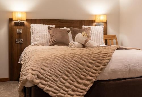 a large bed with a blanket and pillows at Cropton Lodge at Galtres Retreat in Pickering