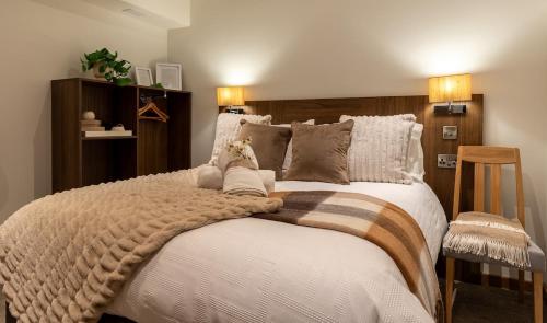 a bedroom with a large bed with a blanket on it at Cropton Lodge at Galtres Retreat in Pickering