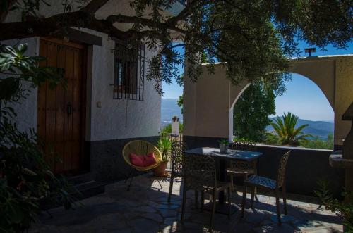 a patio with a table and chairs and a door at Casa Número 5 in Válor