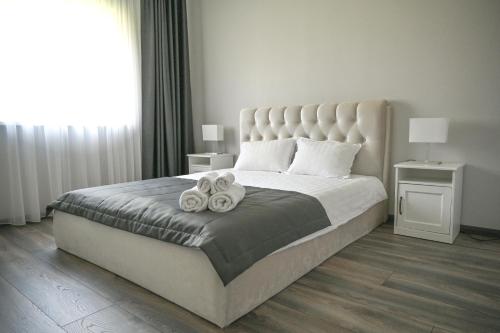 a bedroom with a large bed with towels on it at Kintų Perlas Villa 4B in Kintai