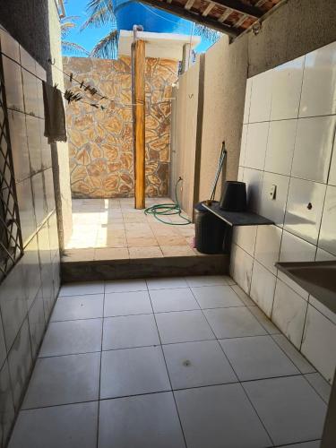 an empty room with a tile floor and a wall at Sua casa no litoral III in Luis Correia