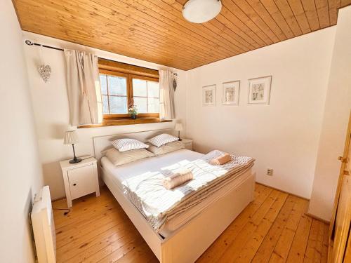a bedroom with a bed with a wooden ceiling at Drevenica Veverica v Terchovej in Terchová