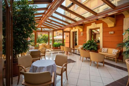 a conservatory with tables and chairs in a restaurant at Hotel Careni Villa Italia in Finale Ligure
