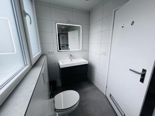 a bathroom with a toilet and a sink and a mirror at Bungalowpark Simpelveld - Delta 125 in Simpelveld