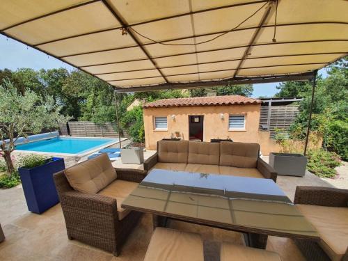 un patio avec une table et des chaises et une piscine dans l'établissement Chez Mylène et Jean, à Bédoin