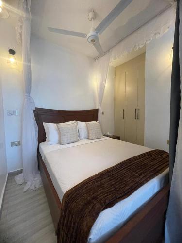 a bedroom with a large bed with a brown blanket at Zuri Twin Sands Beach Properties - Malindi in Malindi
