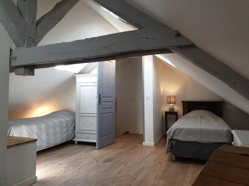 Cette chambre mansardée dispose de 2 lits et d'un lit. dans l'établissement Gîtes Auversois, à Auvers-Saint-Georges