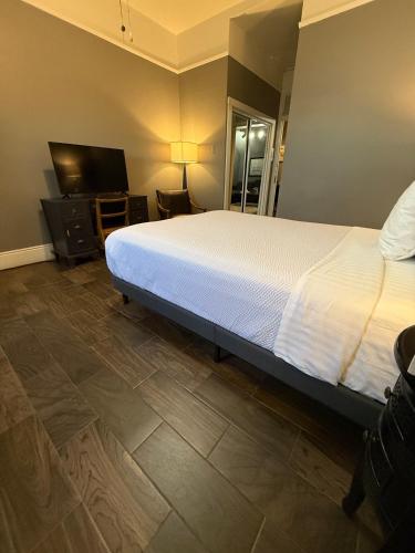 a bedroom with a bed and a flat screen tv at The Gadsden Hotel in Douglas