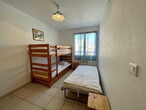 a room with two bunk beds and a window at Les forestiers 2 in Mimizan