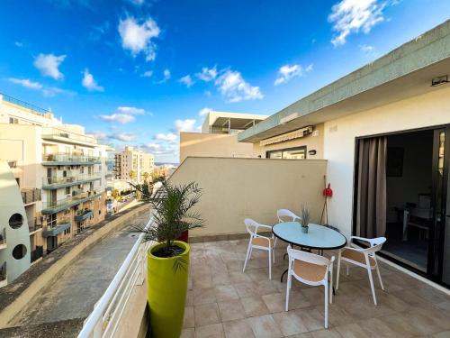 a patio with a table and chairs on a balcony at Triton Mansion D26 - Entire Unit in St Paul's Bay
