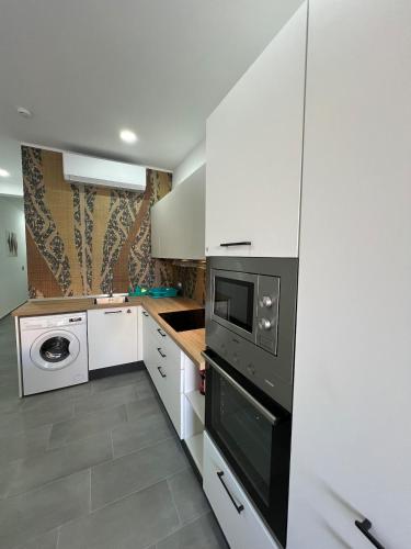 a kitchen with white cabinets and a black appliance at Triton Mansion D26 - Entire Unit in St. Paul's Bay