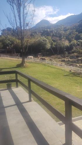 einen Park mit einem Zaun und einem Feld mit Tieren in der Unterkunft Chalé 2 in Nova Friburgo