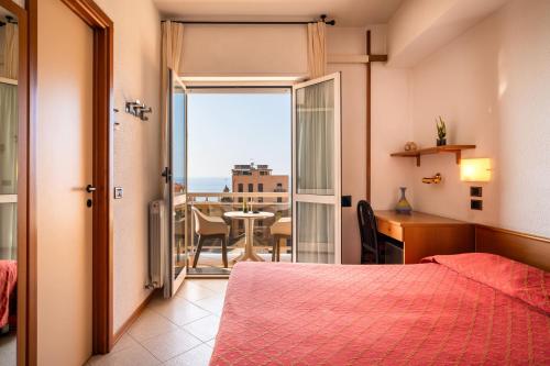 een slaapkamer met een bed en een balkon met een tafel bij Hotel Careni Villa Italia in Finale Ligure