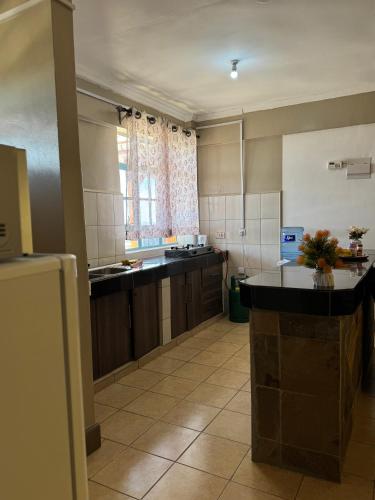 a large kitchen with wooden cabinets and a window at Aquene By Rorric Safaris in Nanyuki